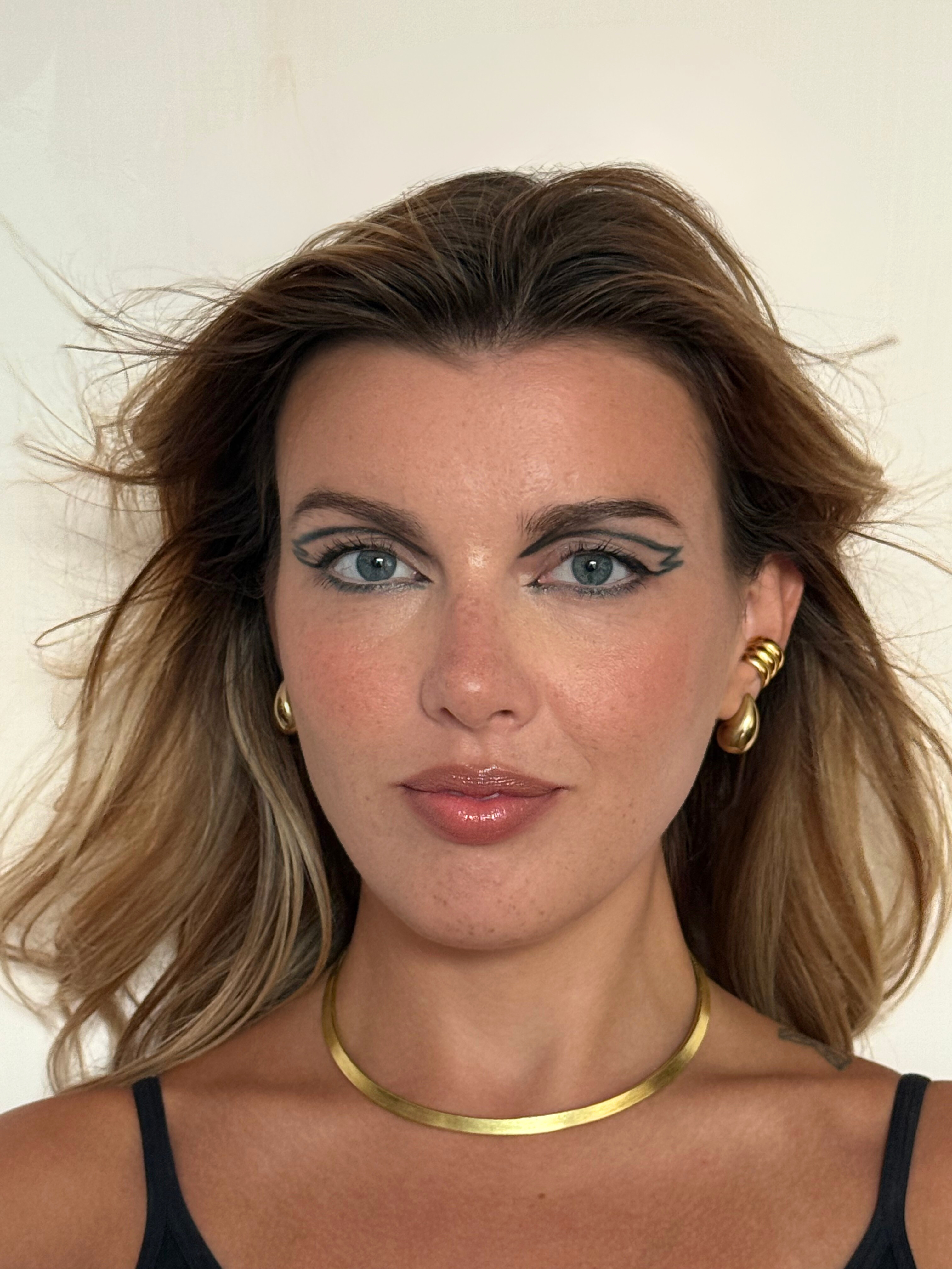 A geometric eyeliner that defines the gaze, balanced by natural, luminous lips.